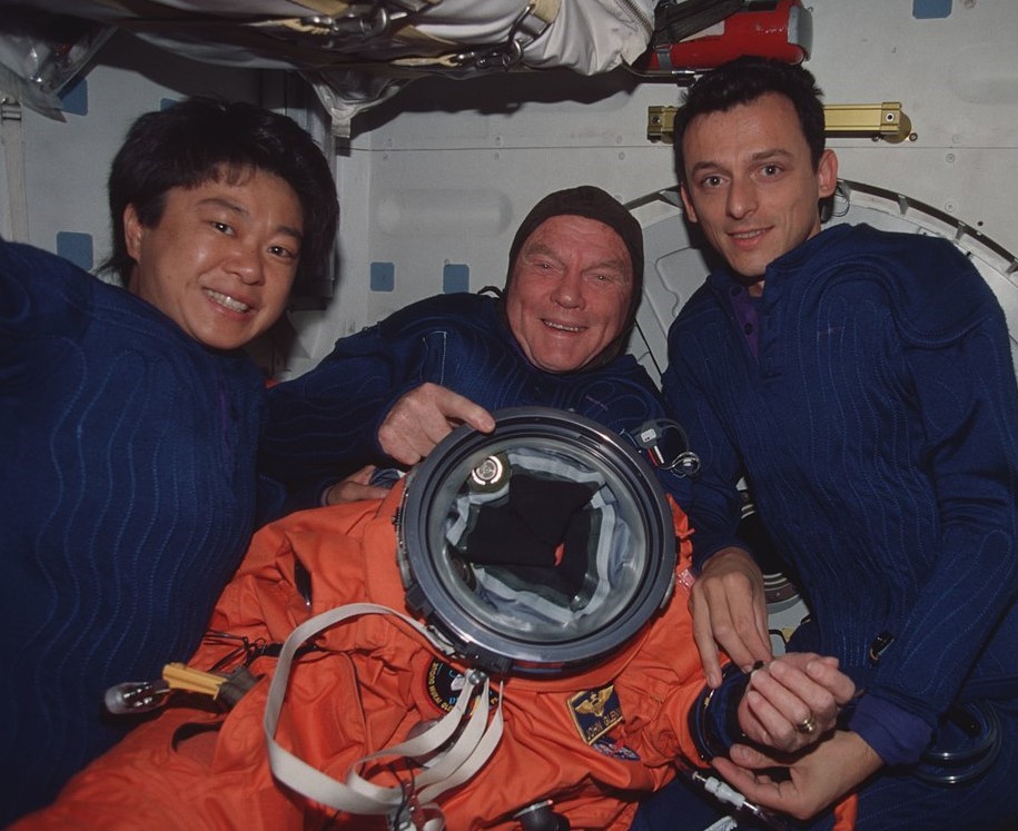Mukai, left, and Duque help Glenn, center, put on his launch and entry suit for reentry