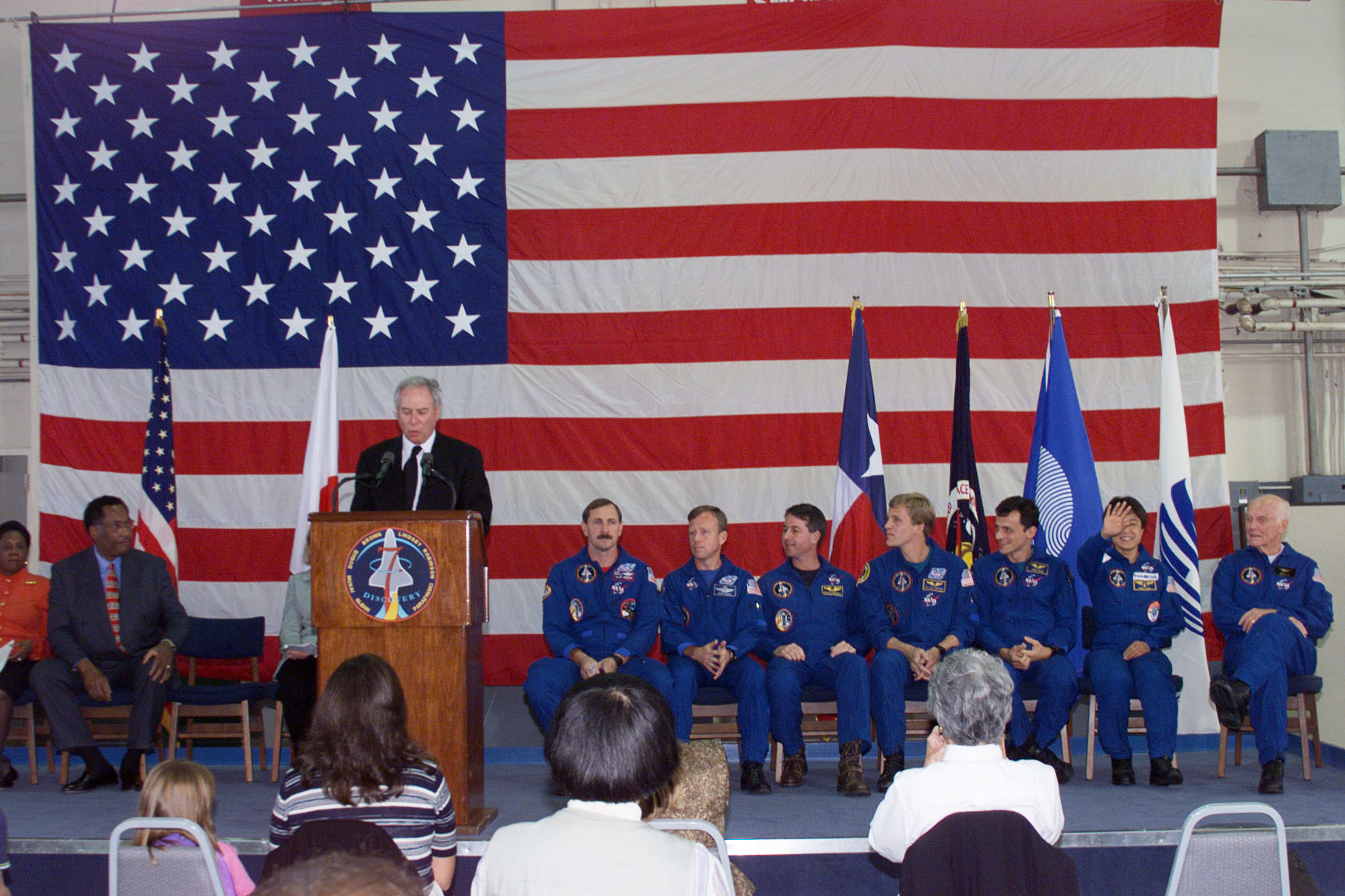NASA Administrator Daniel S. Goldin addresses the crowd at Ellington as the STS-95 astronauts listen