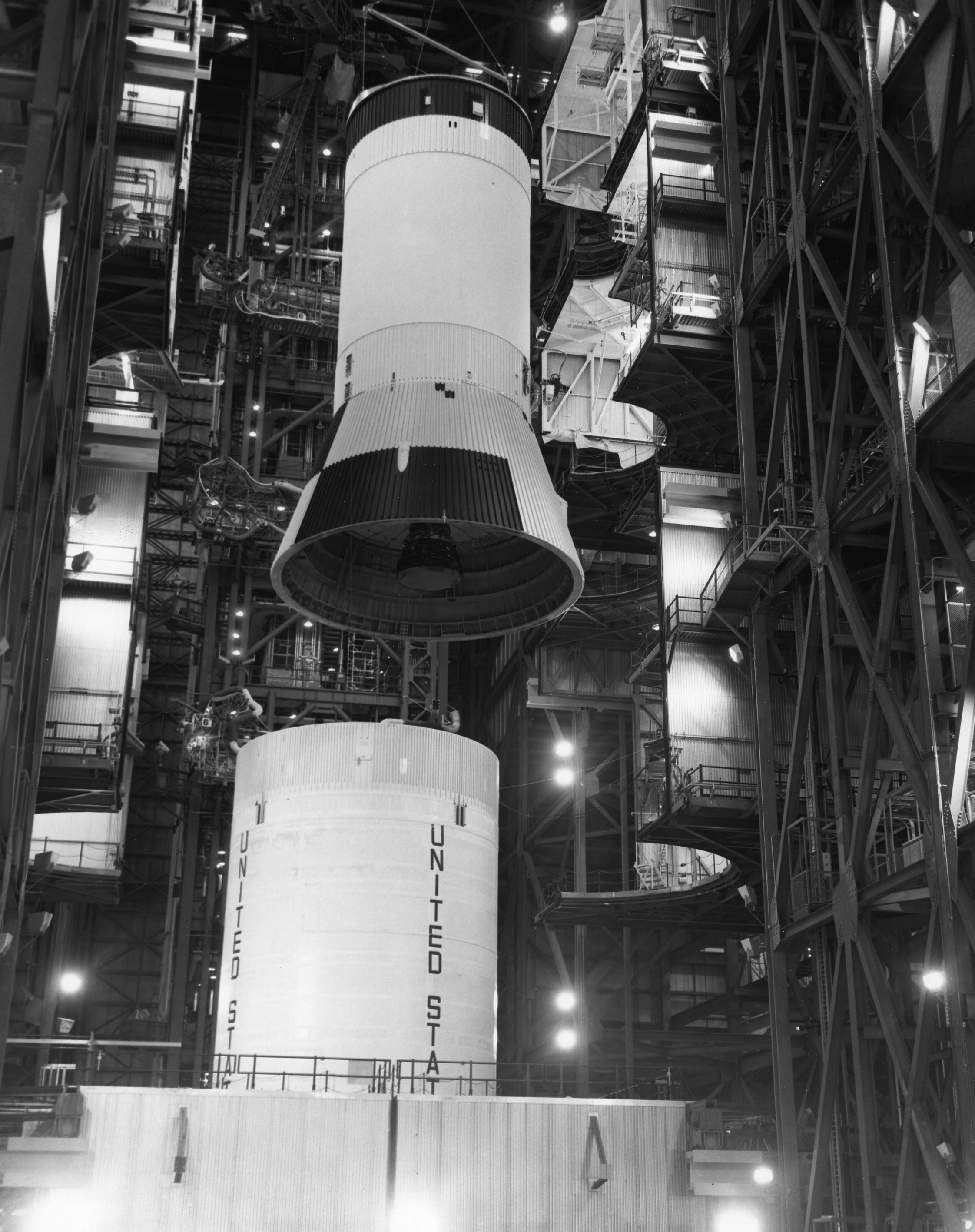 Workers in the Vehicle Assembly Building at NASA’s Kennedy Space Center (KSC) in Florida lower the S-IVB third stage onto the S-II second stage during stacking operations of the Apollo 9 Saturn V