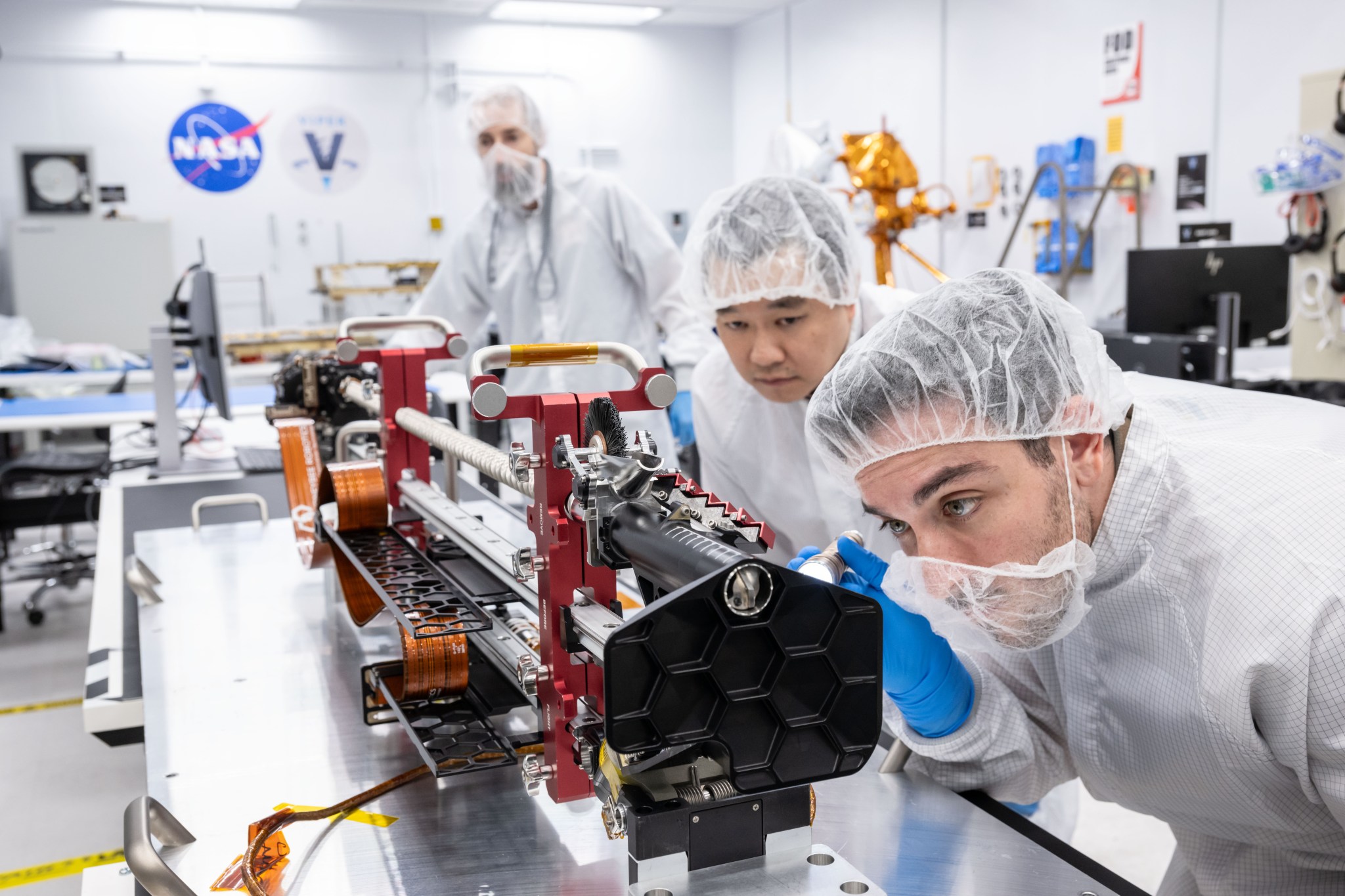Engineers inspect the TRIDENT drill in a clean room.