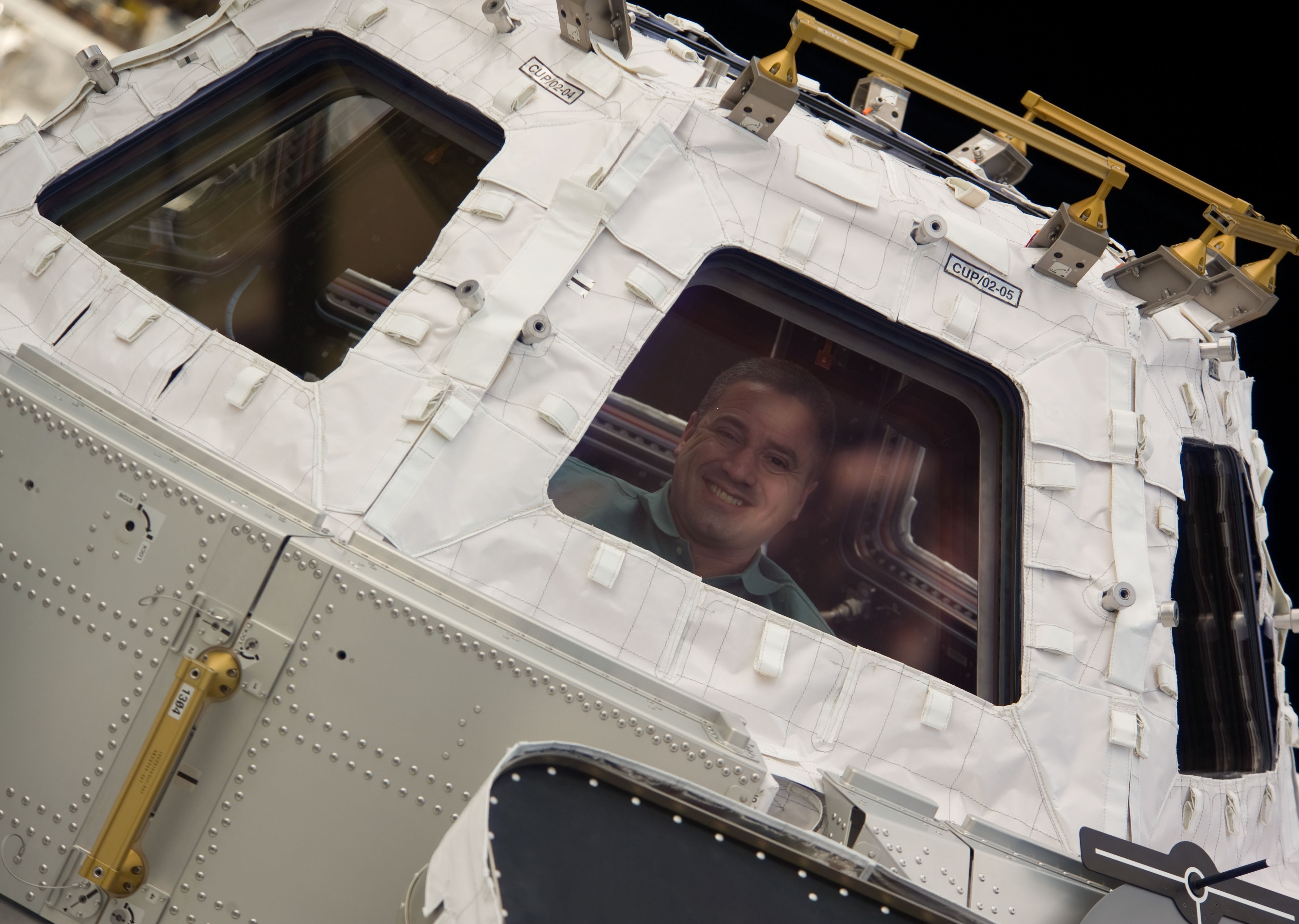 NASA astronaut George D. Zamka peering through one of the Cupola’s windows