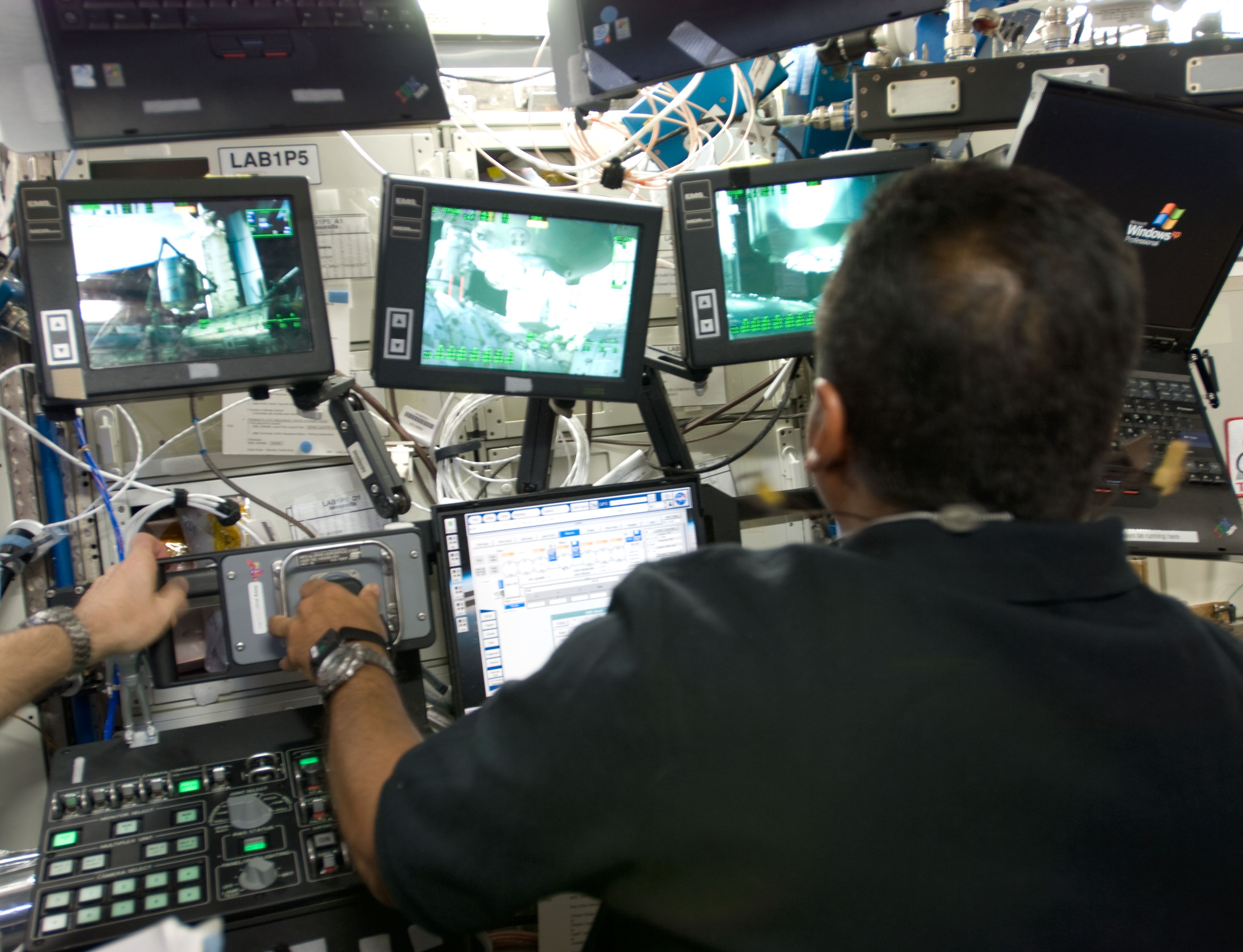 NASA astronaut José M. Hernández operating the station’s robotic arm to return the MPLM to the shuttle’s payload bay.