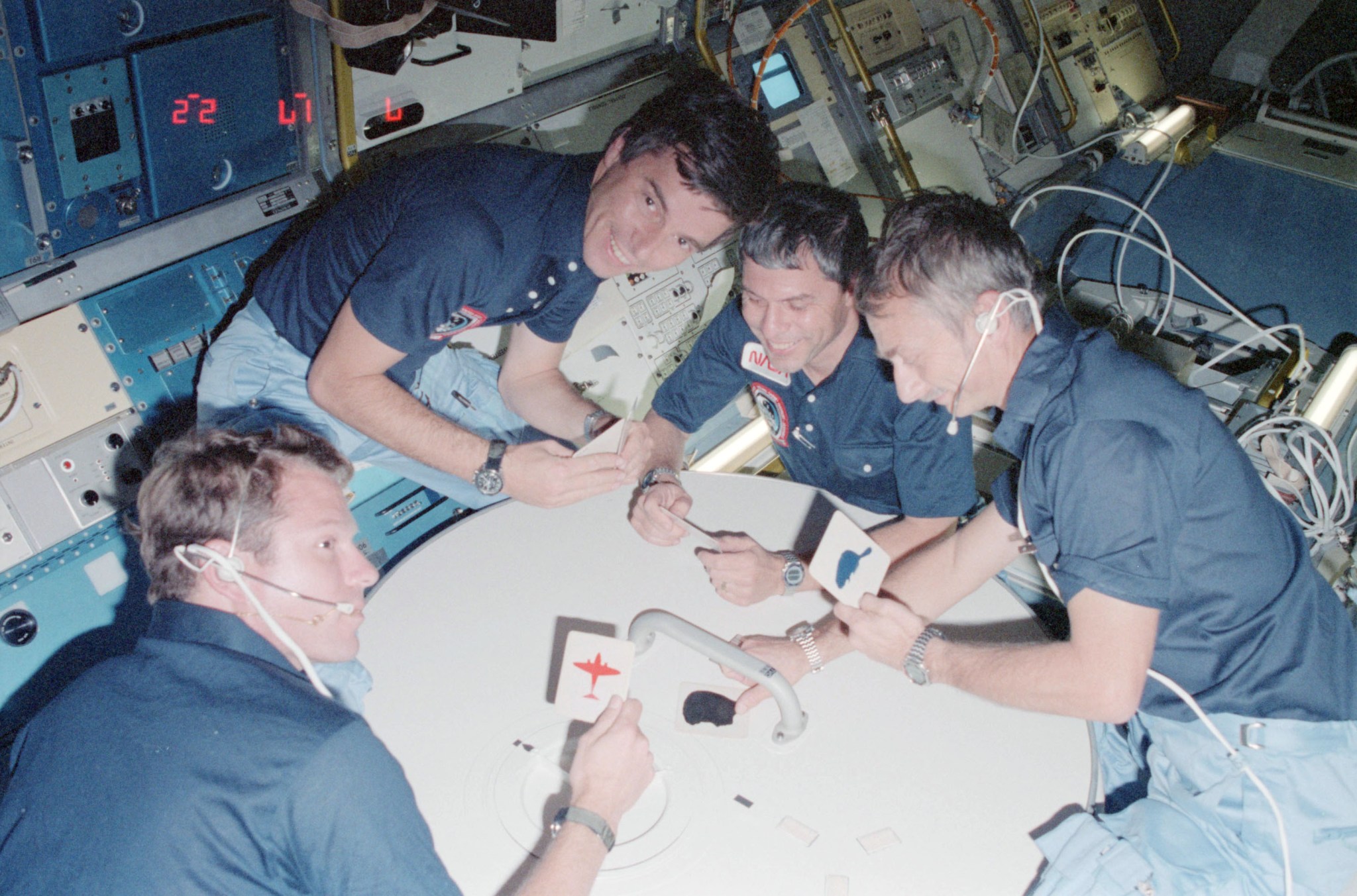 Four STS-9 crewmembers play a fun game with cards during their mission.