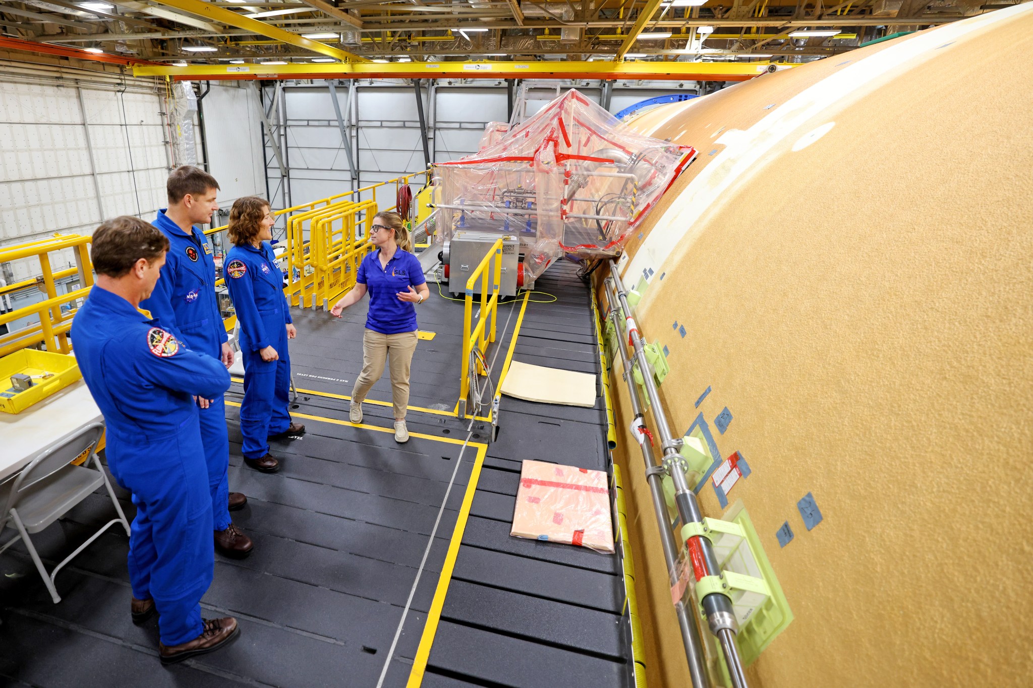 Artemis II NASA astronauts Reid Wiseman and Christina Koch of NASA, and CSA (Canadian Space Agency) astronaut Jeremy Hansen view the core stage for the SLS (Space Launch System) rocket at the agency’s Michoud Assembly Facility in New Orleans on Nov. 16.