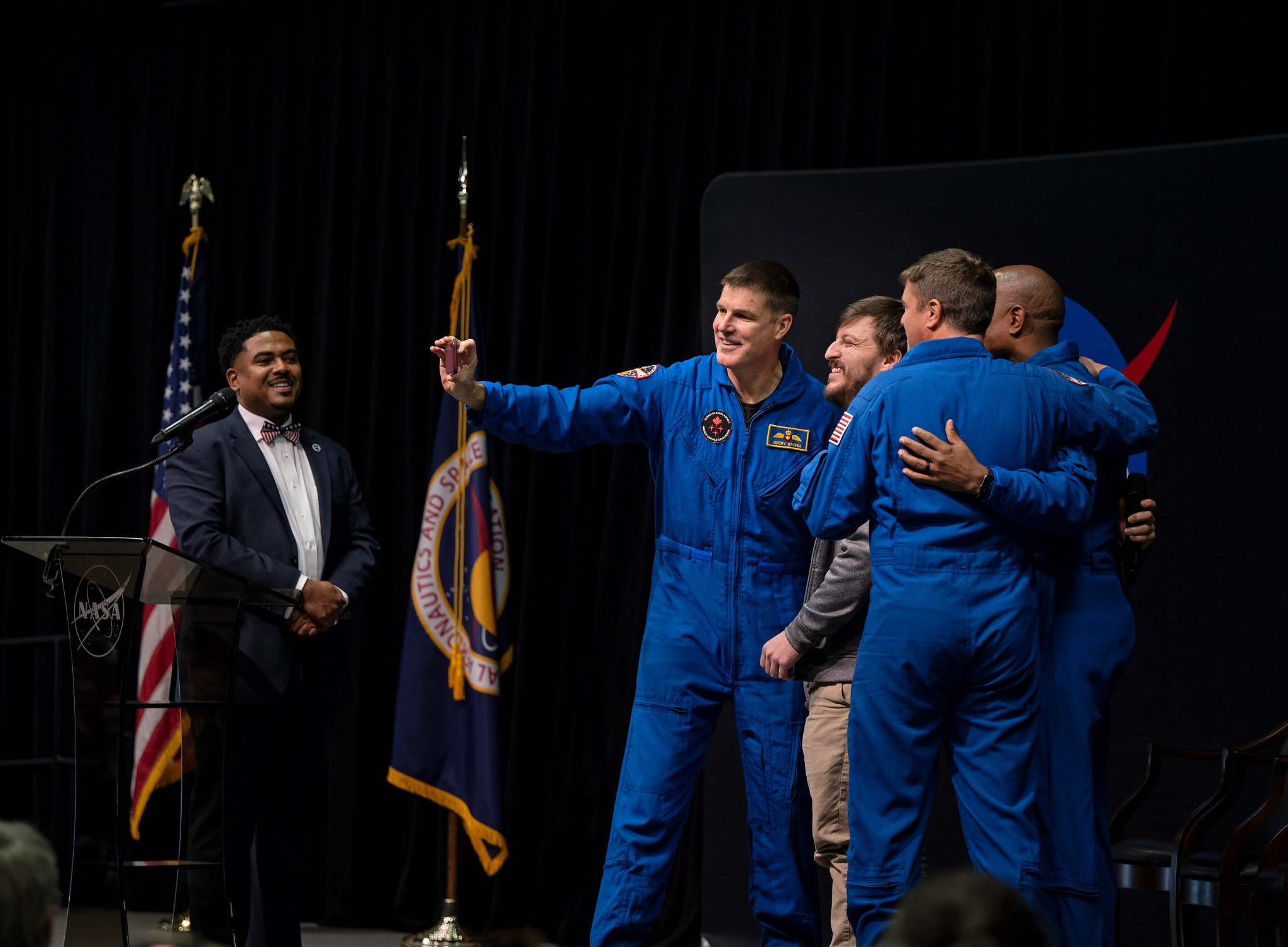 Corey Walker, an atmospheric science programmer at Marshall with Jacobs, smiles with the astronauts as they record a video wishing Walker’s grandmother, Brenda Lowery, merry Christmas. During a question and answer session with the astronauts, Walker asked if he could get a video of them for his grandmother as a Christmas gift for her. Walker said his grandmother loves the space program. At far left is Lance D. Davis, Marshall’s news chief, who served as moderator for the event.