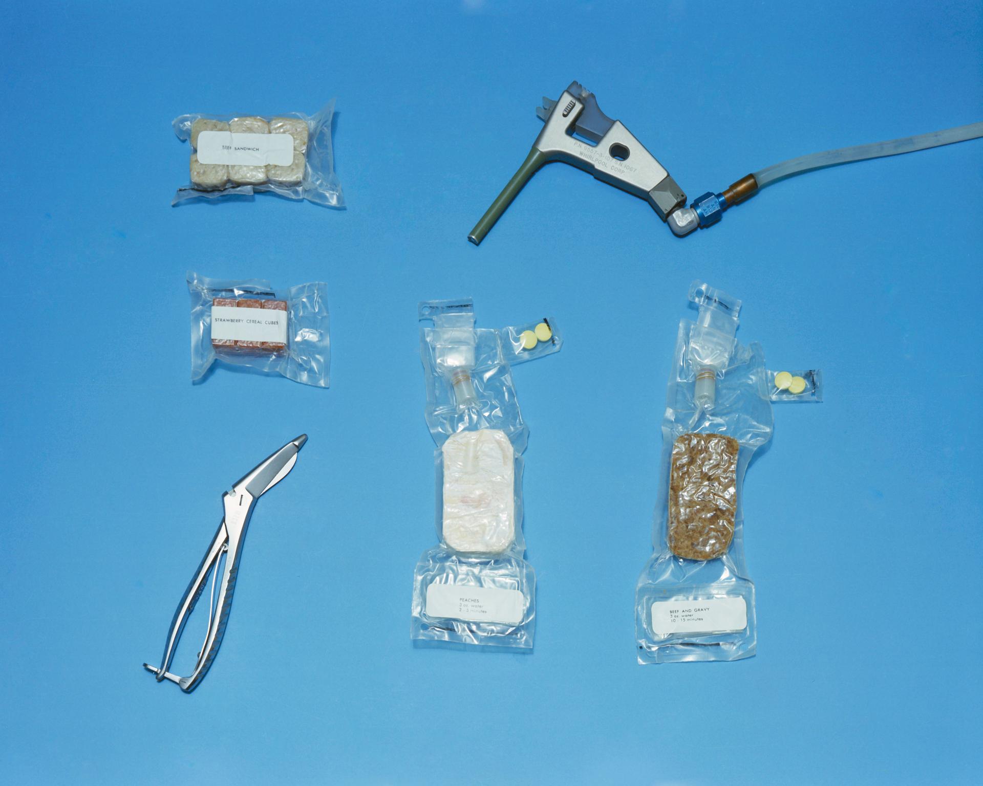 An array of food items and related implements used on the Gemini-Titan 4 mission