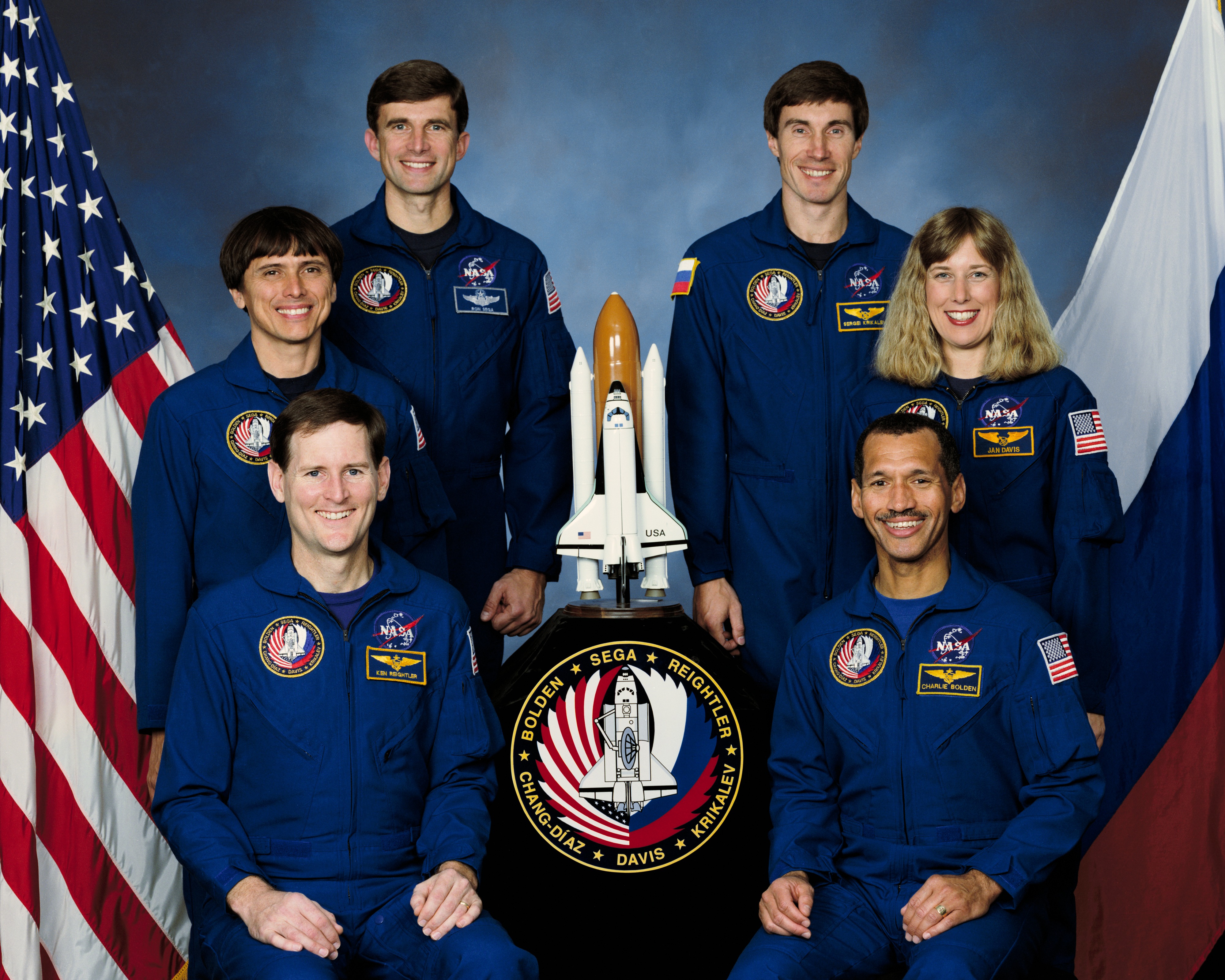 The STS-60 crew of (clockwise from bottom left) Pilot Kenneth S. Reightler, Mission Specialists Franklin R. Chang-Díaz, Ronald M. Sega, Sergei K. Krikalev representing the Russian Space Agency, now Roscosmos, and N. Jan Davis, and Commander Charles F. Bolden