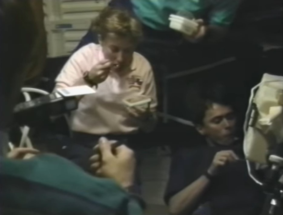 The STS-60 crew enjoys ice cream stored in the freezer