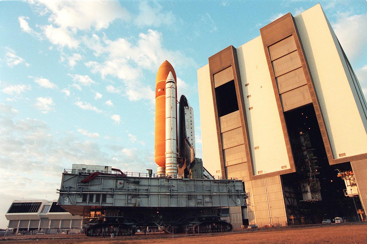 Space shuttle Discovery departs the Vehicle Assembly Building on its way to Launch Pad 39A