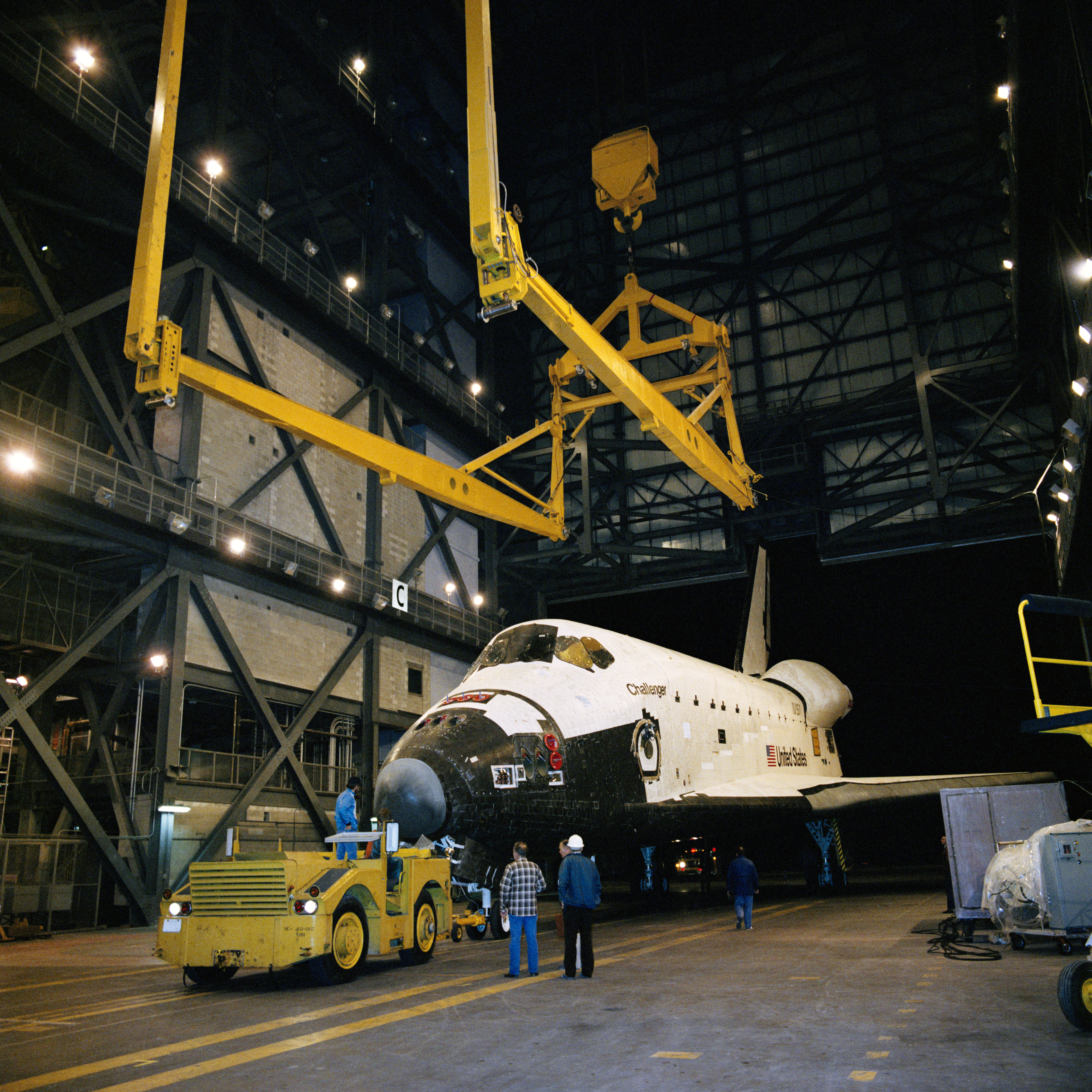 Workers in the VAB prepare to lift space shuttle Challenger to mate it with its External Tank and twin Solid Rocket Boosters